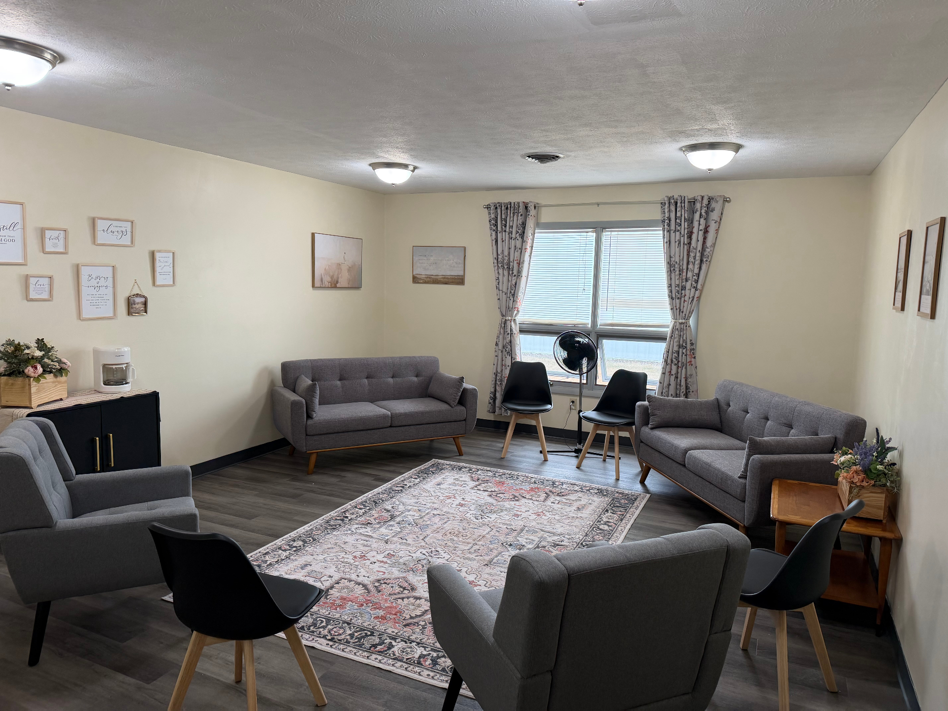 After — Church classroom transformed into a warm, welcoming lounge with cozy seating, layered rug, and styled gallery wall