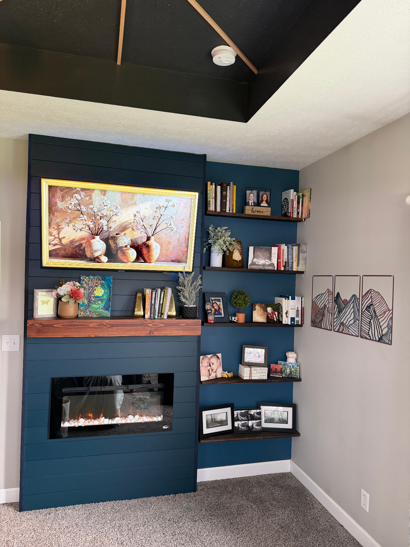 After — Master bedroom feature wall with navy shiplap fireplace, built-in shelving, and curated styling