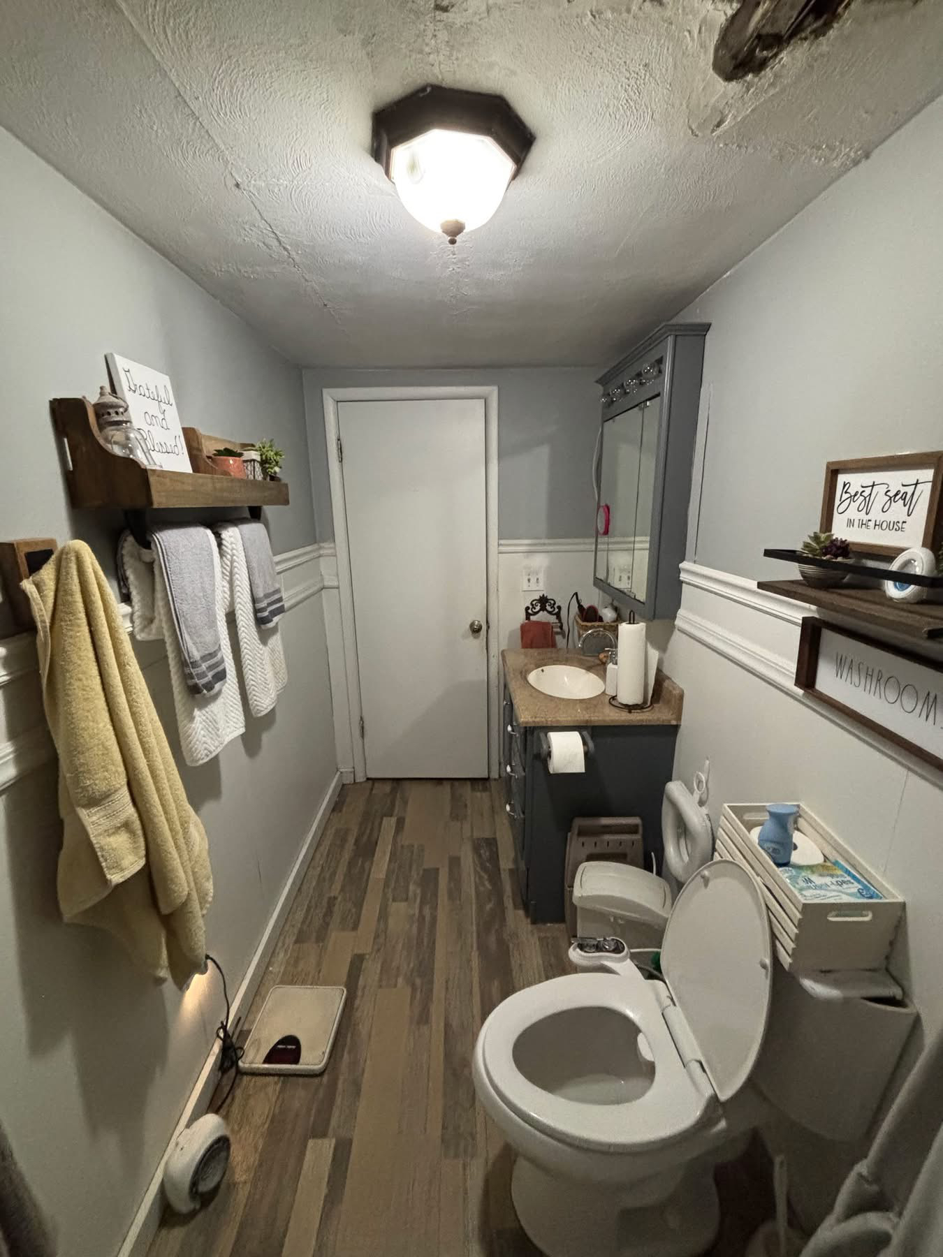 Before — Bathroom with new board-and-batten wainscoting, curtains, and styled decor